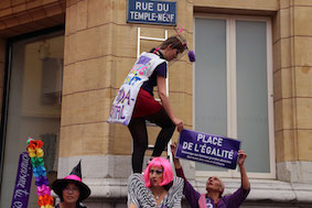 Une manifestante sur une échelle renomme change le nom de la rue du Temple-Neuf qui devient Place de l'Egalité.