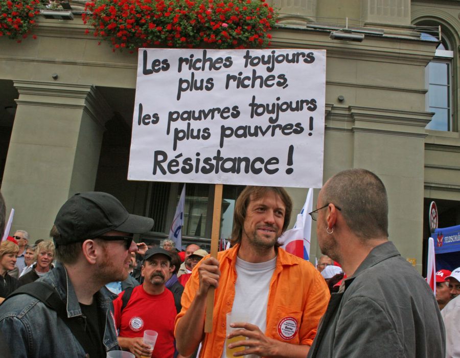 Pancarte "Les riches toujours plus riches, les pauvres toujours plus pauvre" lors d'une manifestation.