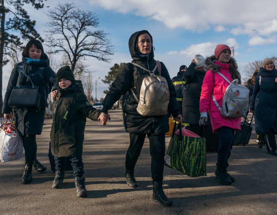 Réfugiés à pied chargés de bagages.