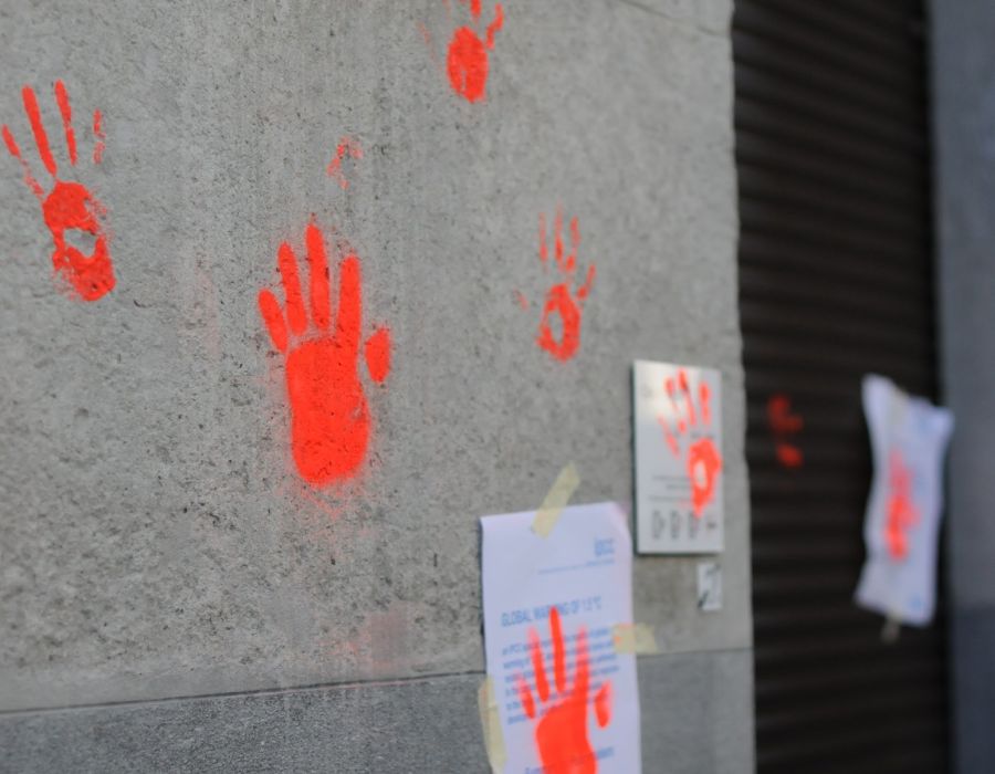 Mains rouges apposées sur un mur.