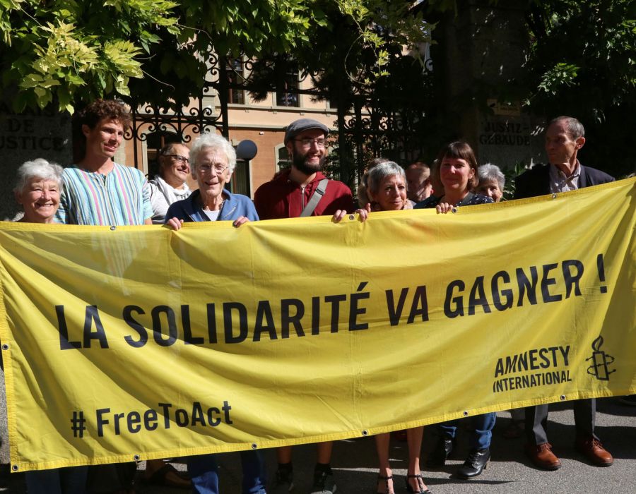 Anni Lanz et ses soutiens brandissant une banderole sur laquelle on peut lire: La solidarité va gagner!