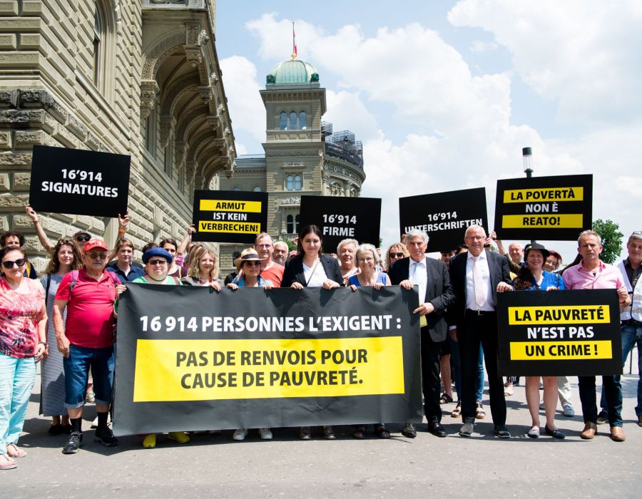 Remise de la pétition à la Chancellerie pour l'Alliance. Une banderole "Pas de renvois pour cause de pauvreté".