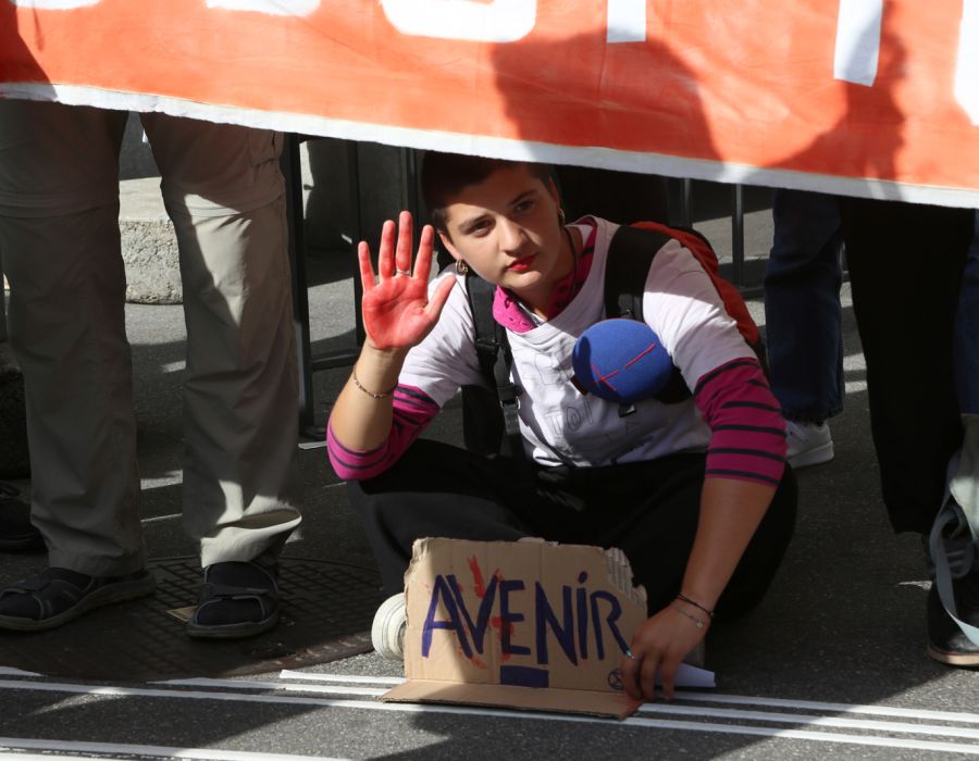 Jeune femme tenant une pancarte sur laquelle on peut lire "Avenir".