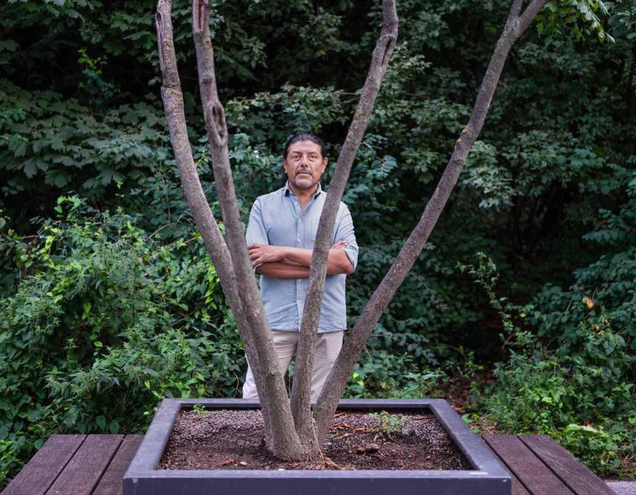 Portrait de Christian Palma Allende entouré d'arbres.