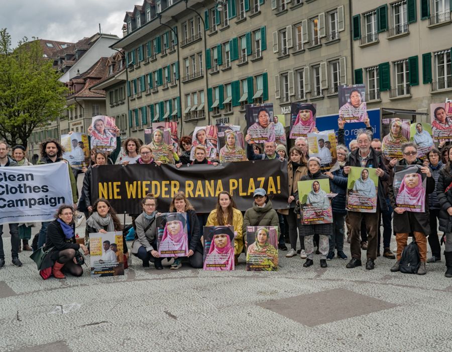 Commémoration à Berne. Les participants brandissent les portraits de victimes.