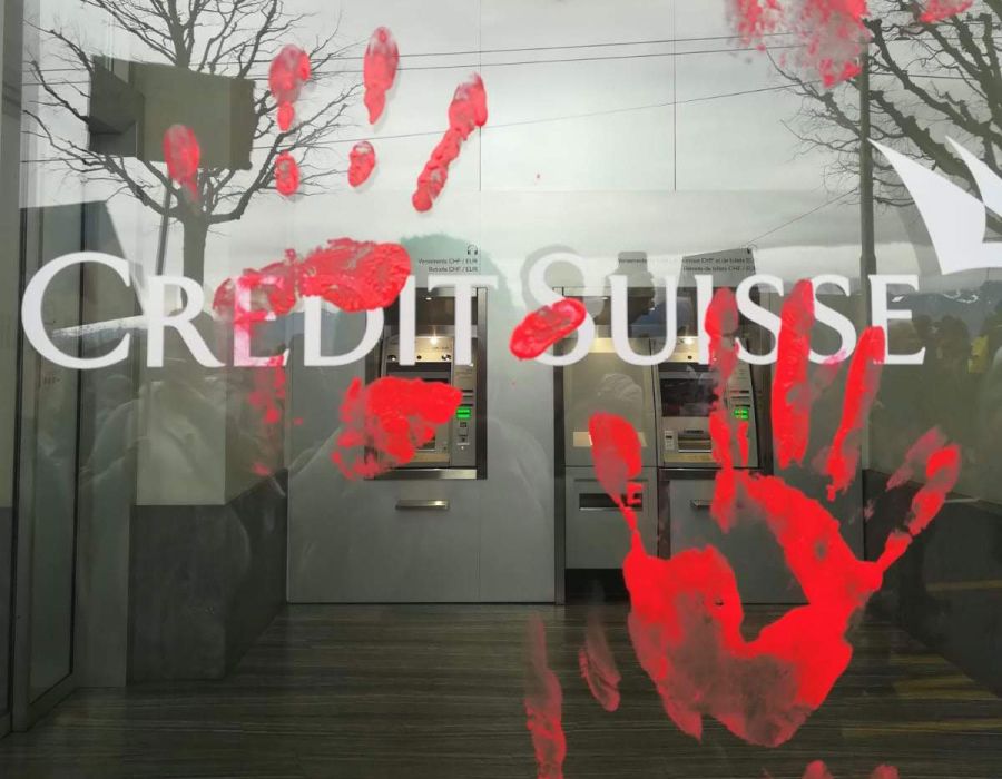 Empreintes de mains rouges sur une vitrine Credit Suisse.