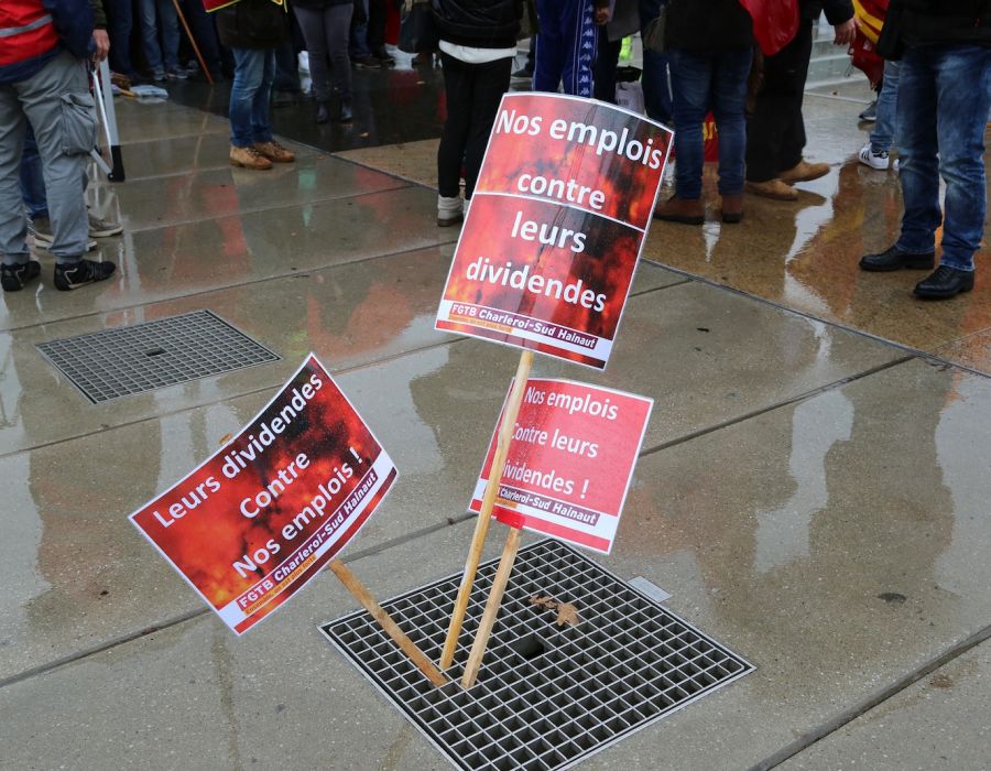 Pancartes: "Leurs dividendes contre nos emplois", "Nos emplois contre leurs dividendes".