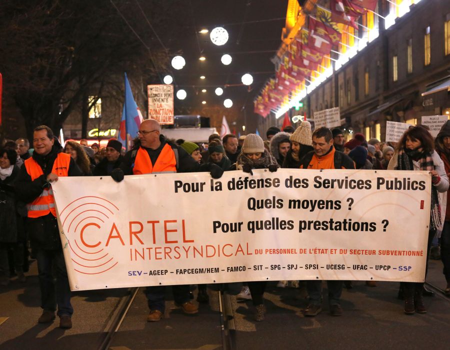 Manifestation avec une banderole du cartel intersyndical sur laquelle on peut lire: "Pour la défense des services publics. Quels moyens? Pour quelles prestations?"