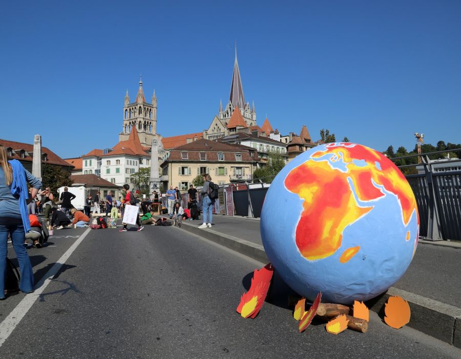 Un globe terrestre qui brûle lors d'une mobilisation en faveur du climat à Lausanne.