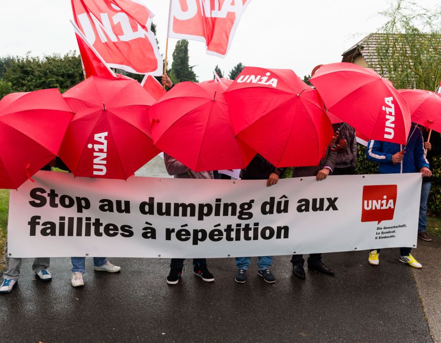 Action Unia avec une banderole sur laquelle on peut lire: Stop au dumping dû aux faillites à répétition.