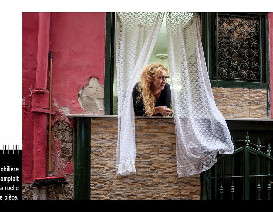 une femme regarde par la fenêtre