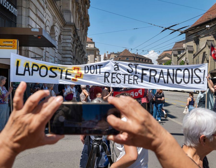 Manifestation devant la poste de St-François. Une banderole: "La poste doit restser à St-François".