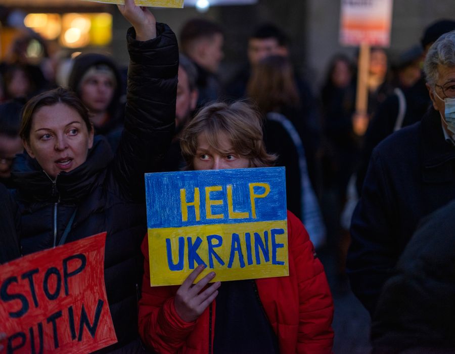 Une femme avec une pancarte "HELP UKRAINE" en bleu et jaune.