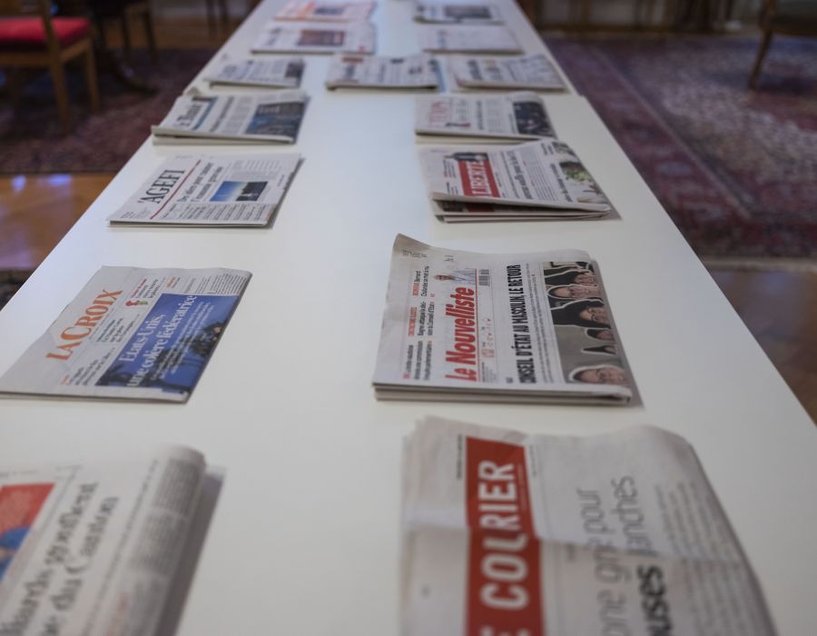 Différents titres de la presse écrite étalés sur une table.