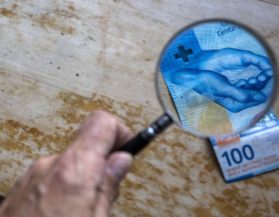 Une loupe est placée au-dessus d'un billet de 100 francs