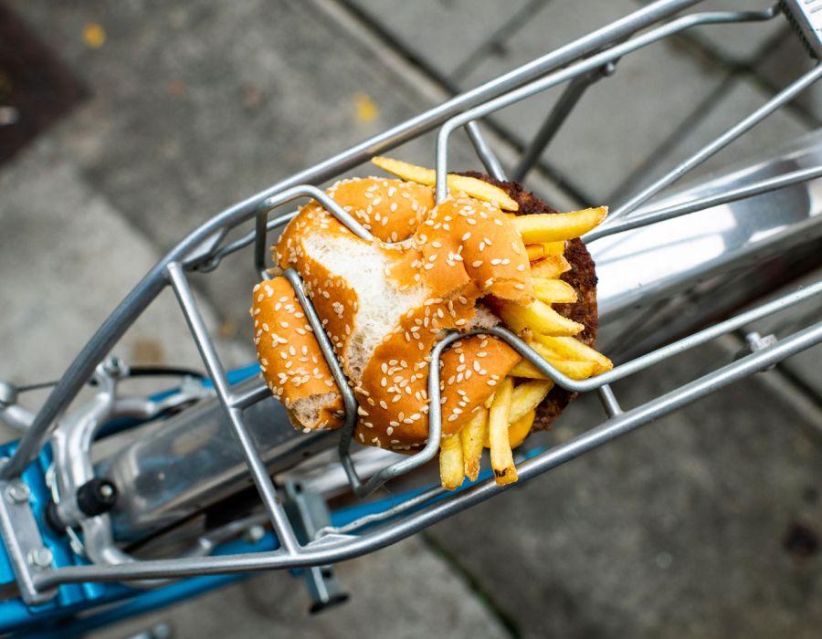 Hamburger et frites écrasés sur le porte-bagage d'un vélo.