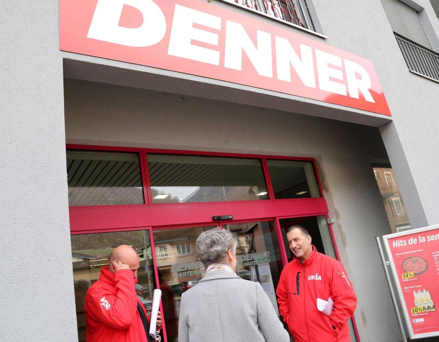 syndicalistes d'unia devant la porte d'un magasin Denner